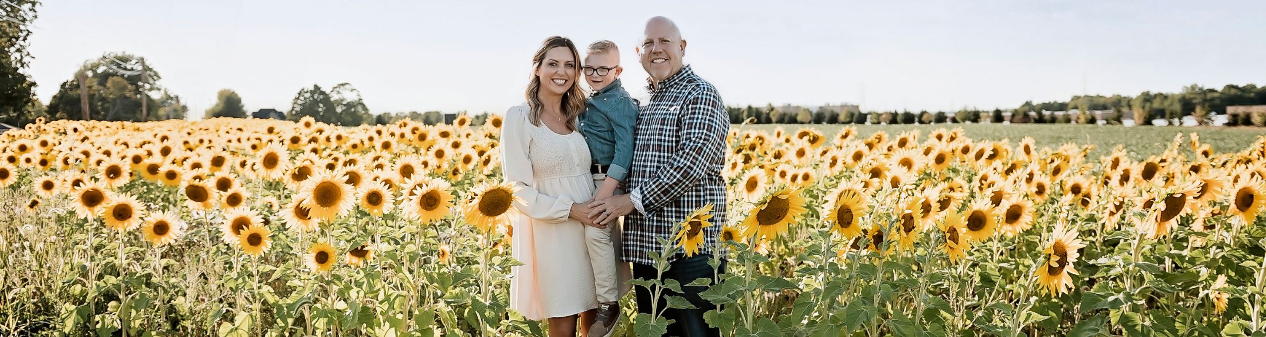 Tammy, Willy, and Will together in a sunflower field